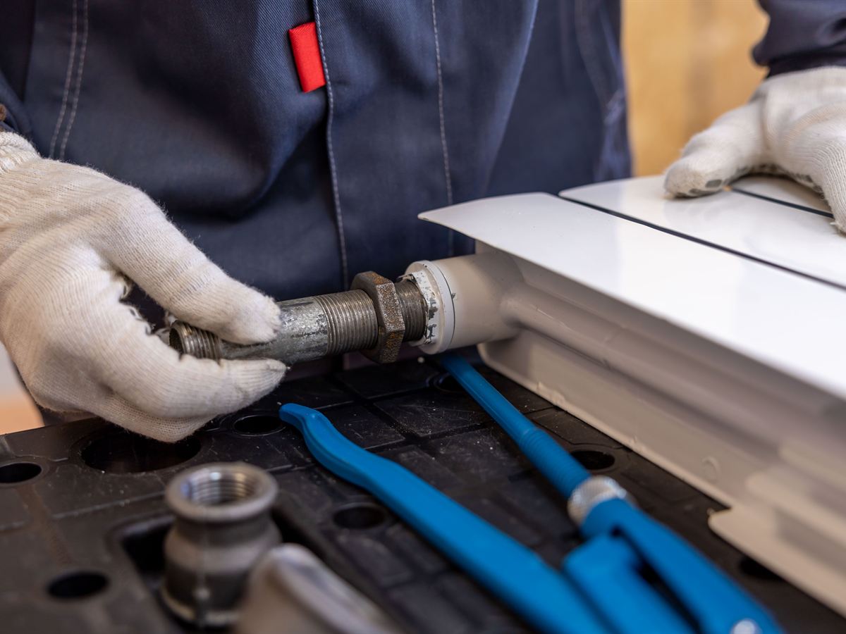 Plumber fitting a pipe connection (illustrative)