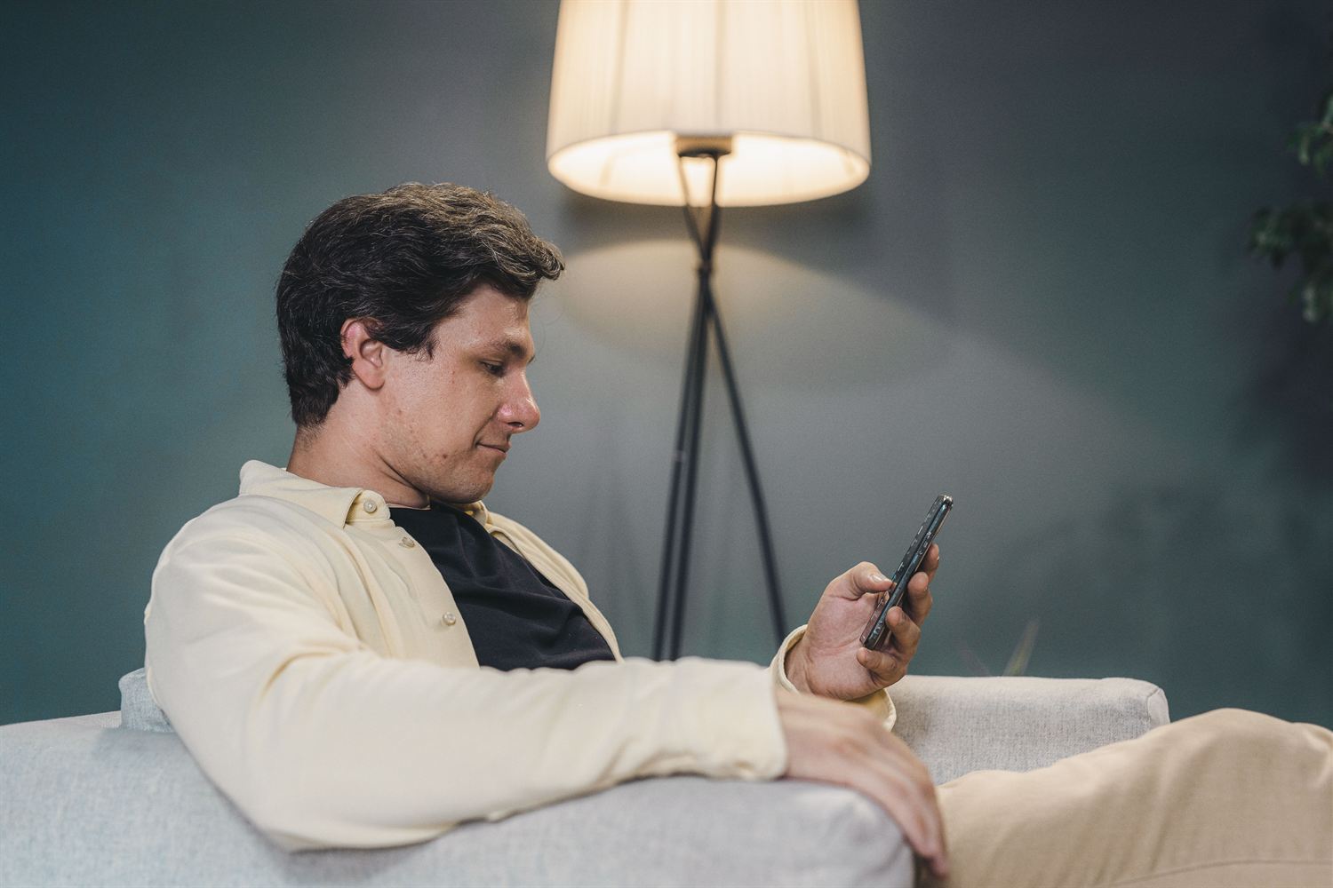 Person scrolling a social media feed on a phone at home